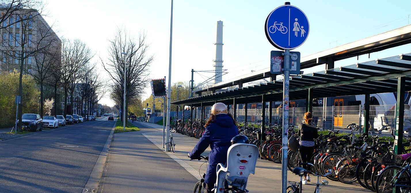Infrastruktur_NRW_Bonn_ADFC_NRW__17_.JPG Bahnhalt, Regionalbahn, Radabstellanlage und eine Radfahrerin.